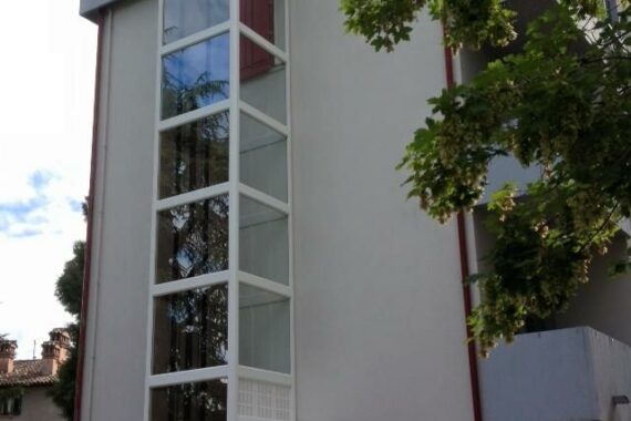 Ascensor exterior instalado en fachada de edificio con estructura de cristal