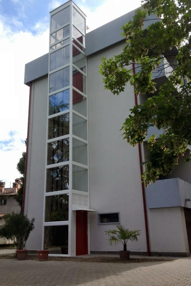 Ascensor exterior instalado en fachada de edificio con estructura de cristal