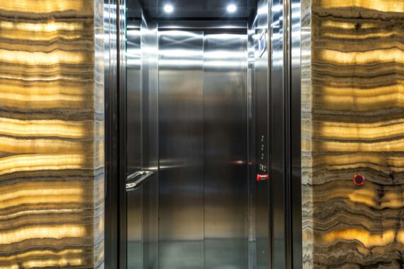 Ascensor moderno con puerta abierta y cortinas luminosas